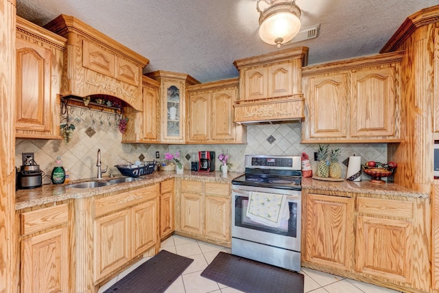 316 Hickman Ln, Angleton, TX 77515 - kitchen featuring a sink, a textured ceiling, light tile patterned floors, and stainless steel electric range oven