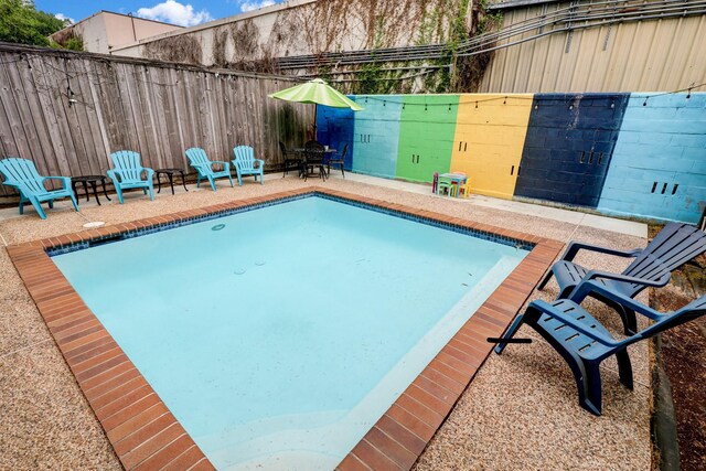 view of swimming pool featuring a fenced in pool, a patio area, and fence