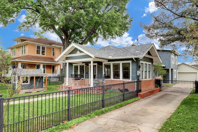 view of front of property featuring a front yard, a shingled roof, a porch, a fenced front yard, and a detached garage