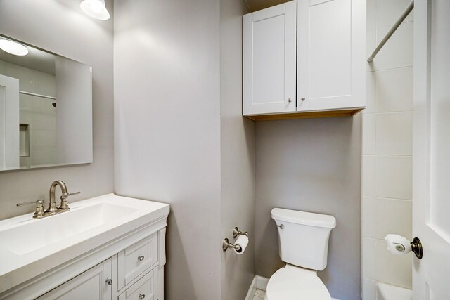 full bathroom with vanity, walk in shower, and toilet