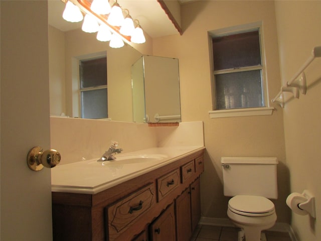 bathroom featuring toilet, tile patterned floors, baseboards, and vanity