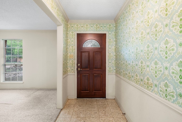 doorway to outside featuring crown molding, a wainscoted wall, wallpapered walls, and a textured ceiling