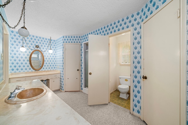bathroom featuring a stall shower, wallpapered walls, a textured ceiling, and toilet