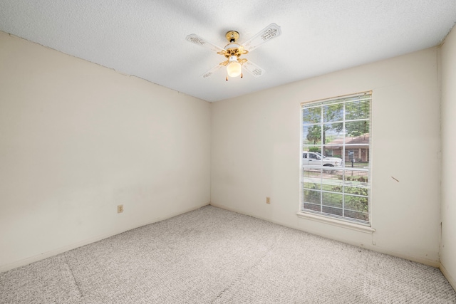 empty room featuring a ceiling fan and carpet flooring