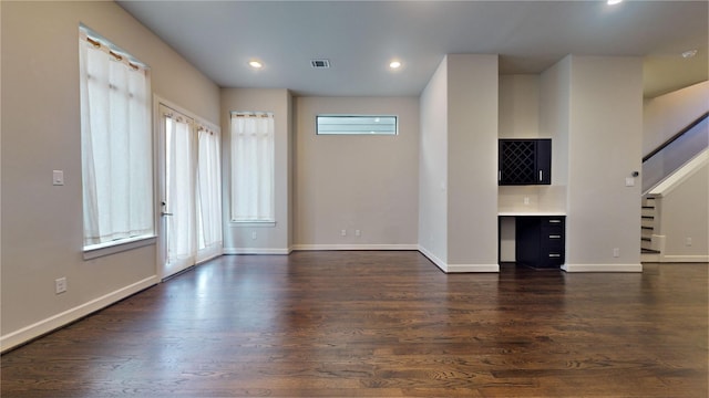 unfurnished living room with recessed lighting, baseboards, dark wood finished floors, and visible vents