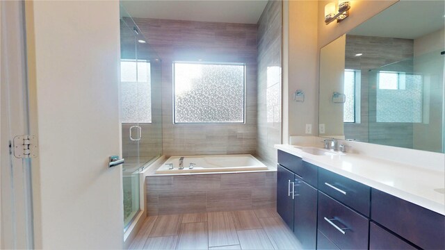 full bathroom with a sink, double vanity, a stall shower, and a garden tub
