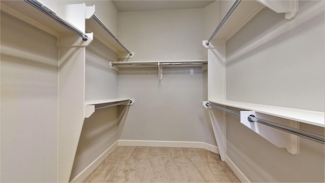 walk in closet with light carpet