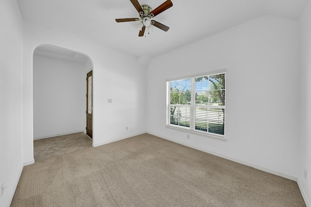 unfurnished room featuring baseboards, arched walkways, ceiling fan, and carpet flooring