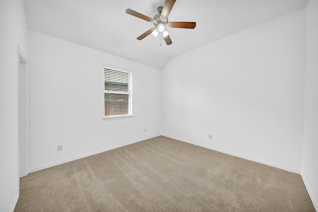 carpeted spare room featuring a ceiling fan, baseboards, and lofted ceiling