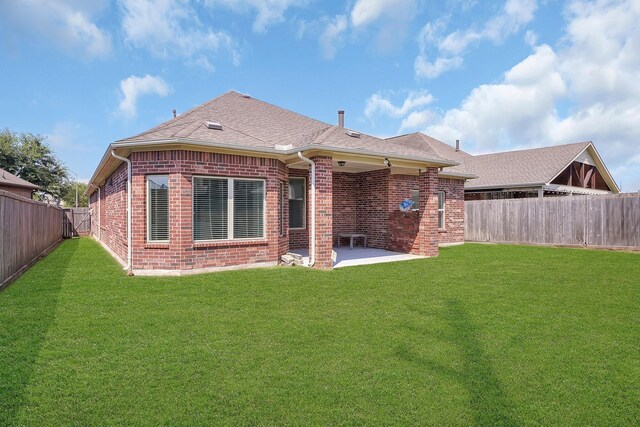back of property featuring a patio area, brick siding, a fenced backyard, a yard, and a shingled roof