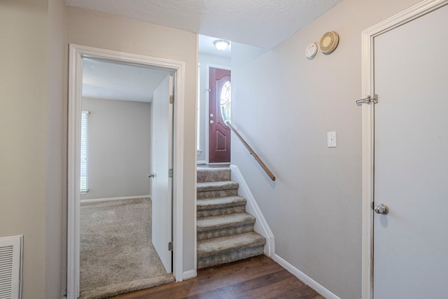 staircase with visible vents, baseboards, wood finished floors, and a wealth of natural light