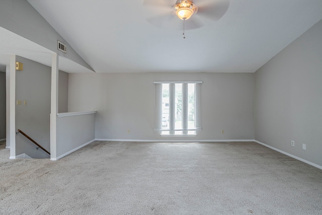 carpeted spare room with a ceiling fan, baseboards, visible vents, and vaulted ceiling