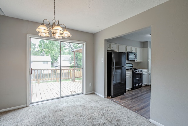 kitchen with dark carpet, baseboards, white cabinets, a chandelier, and black appliances