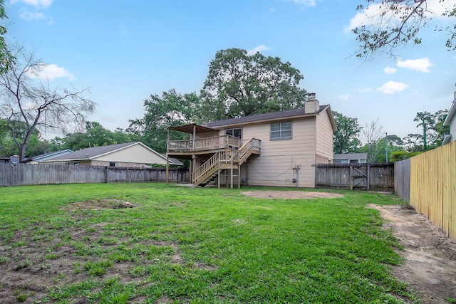 rear view of property with a deck, a fenced backyard, a chimney, a lawn, and stairway
