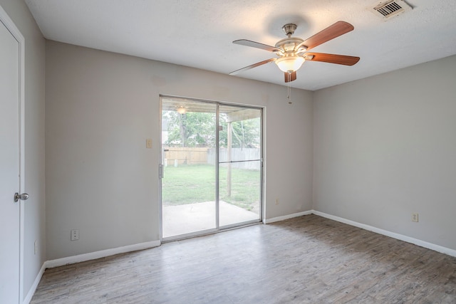 unfurnished room featuring baseboards, ceiling fan, visible vents, and wood finished floors