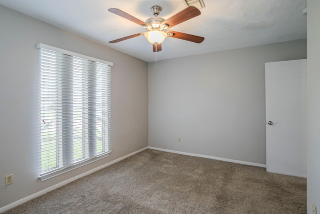 empty room with baseboards, a ceiling fan, and carpet flooring