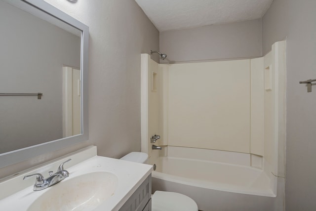 bathroom featuring vanity, a textured ceiling, tub / shower combination, and toilet