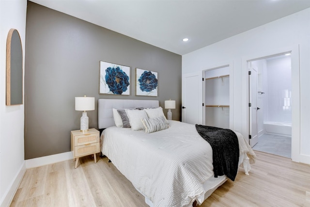 bedroom featuring connected bathroom, baseboards, light wood finished floors, and a closet