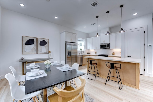 dining room featuring light wood-style floors, recessed lighting, and visible vents