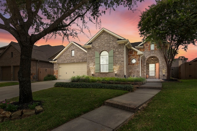 view of front facade with a garage, brick siding, fence, a front lawn, and concrete driveway