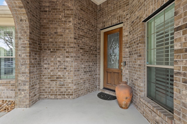 doorway to property featuring brick siding