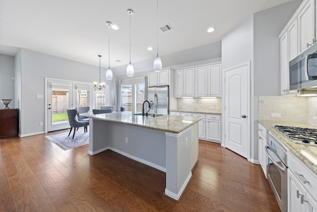 kitchen with stainless steel appliances, an inviting chandelier, white cabinetry, and a sink