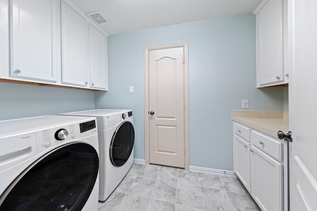 laundry room with baseboards, visible vents, cabinet space, and washer and clothes dryer