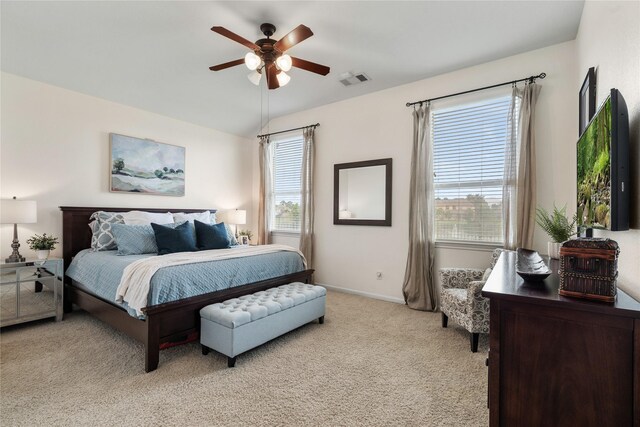 bedroom featuring a ceiling fan, visible vents, light colored carpet, vaulted ceiling, and baseboards