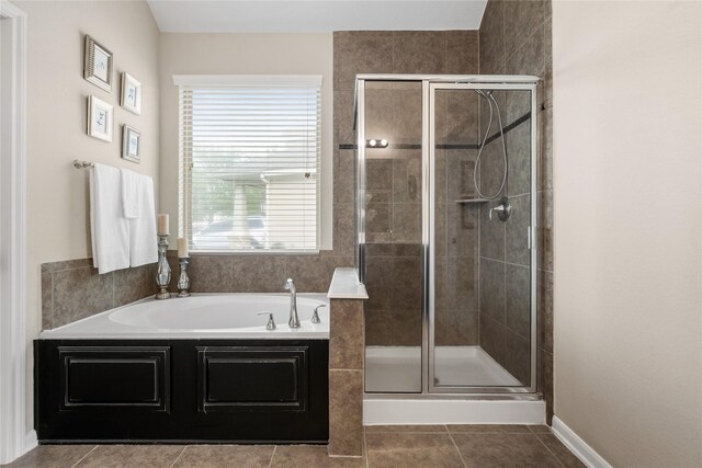 bathroom with a bath, a stall shower, and tile patterned floors