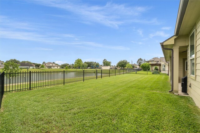 view of yard with a water view, a residential view, and a fenced backyard