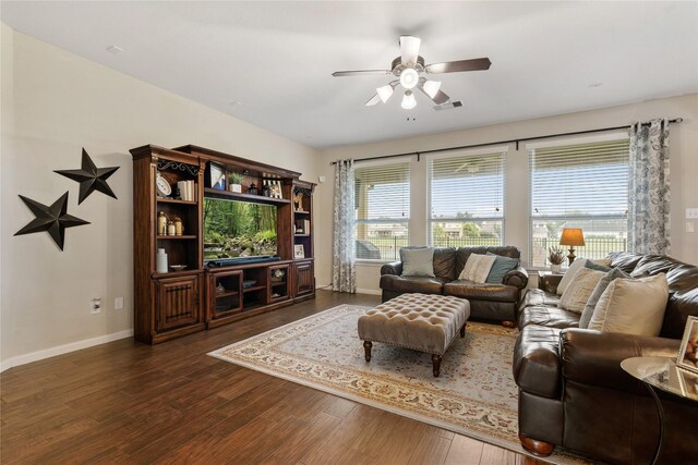 living room featuring visible vents, a ceiling fan, baseboards, and dark wood-style floors