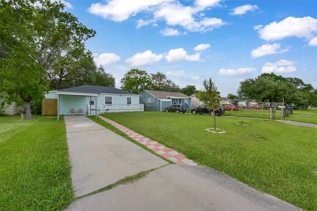single story home featuring a front lawn, fence, driveway, and an attached carport