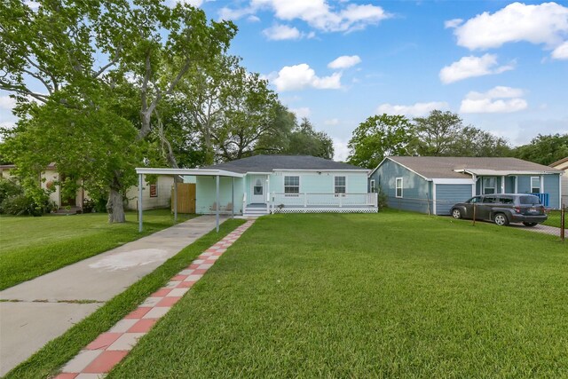view of front of property featuring fence, an attached carport, a porch, a front yard, and concrete driveway