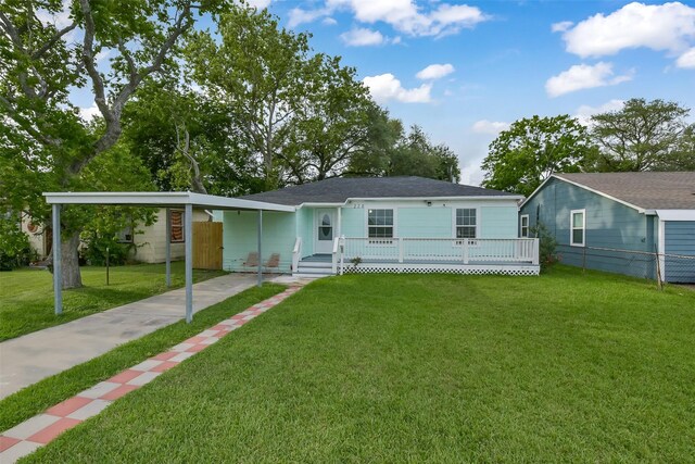 view of front of property with fence, a front lawn, a porch, a carport, and driveway
