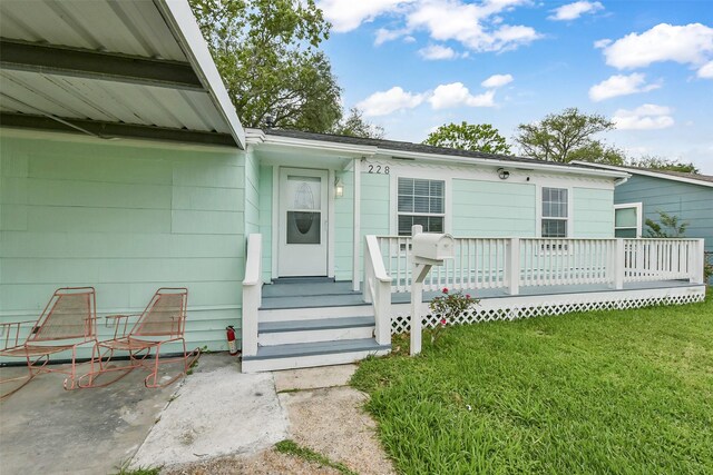 entrance to property with a lawn and a wooden deck