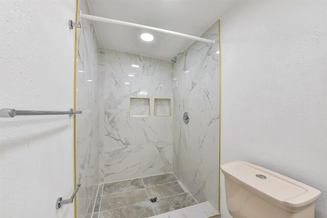 full bathroom featuring toilet, recessed lighting, and a marble finish shower