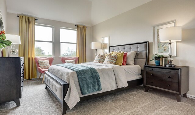 bedroom with light colored carpet and lofted ceiling