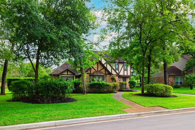 605 N Rivershire Dr, Conroe, TX 77304 - tudor-style house featuring brick siding and a front lawn
