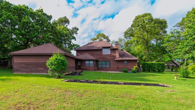 605 N Rivershire Dr, Conroe, TX 77304 - rear view of house featuring a lawn and a chimney