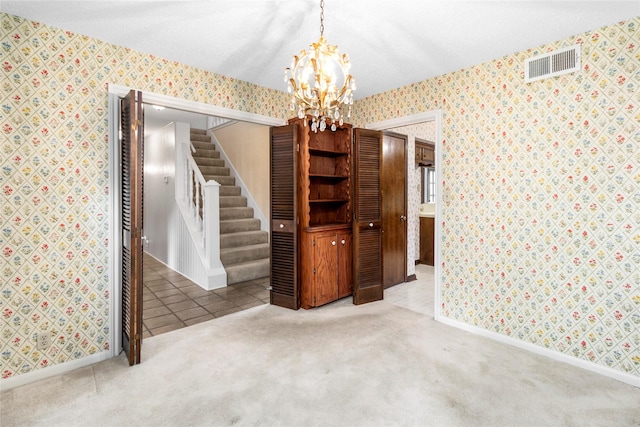 605 N Rivershire Dr, Conroe, TX 77304 - carpeted empty room with a chandelier, baseboards, wallpapered walls, visible vents, and stairway