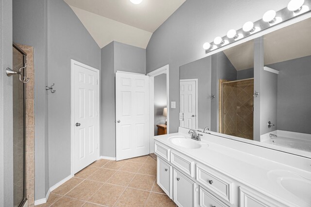 full bathroom with a sink, tile patterned flooring, a shower stall, and double vanity