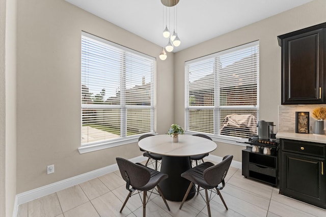 dining area featuring baseboards and plenty of natural light