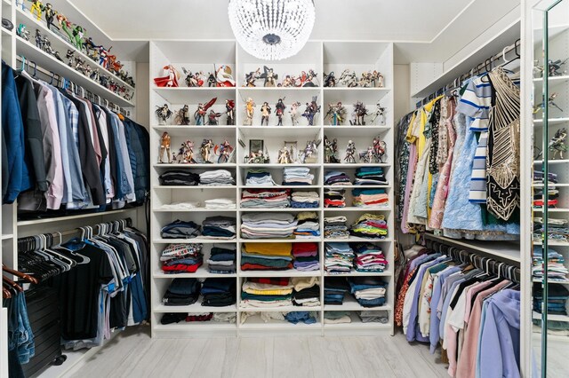 spacious closet with an inviting chandelier