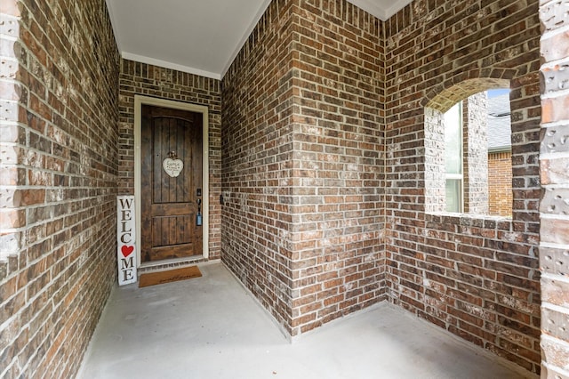 view of exterior entry with brick siding
