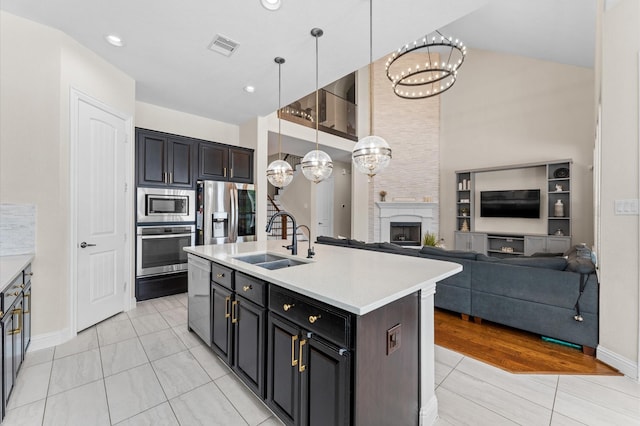 kitchen featuring light countertops, stainless steel appliances, an inviting chandelier, and a sink