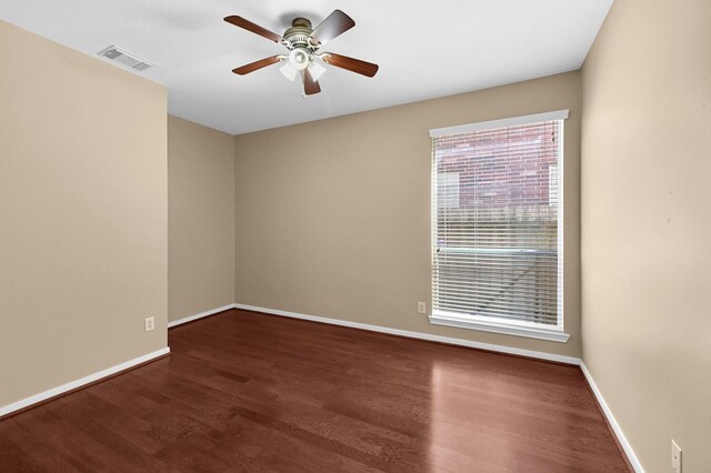 unfurnished room with visible vents, a ceiling fan, baseboards, and wood finished floors
