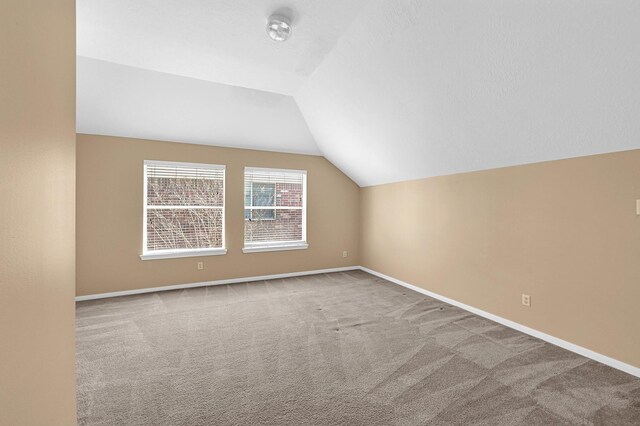 bonus room featuring carpet floors, baseboards, and vaulted ceiling