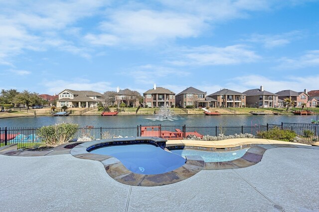 view of swimming pool with a patio, a water view, fence, and a residential view
