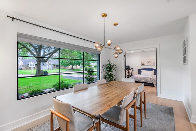 dining space with baseboards and light wood-type flooring