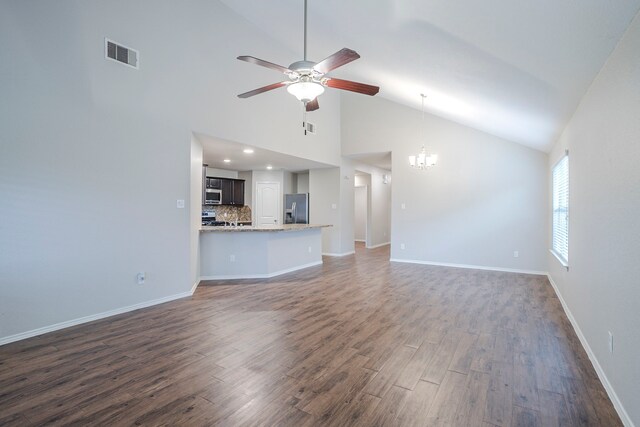 unfurnished living room featuring dark wood-style flooring, visible vents, high vaulted ceiling, baseboards, and ceiling fan with notable chandelier